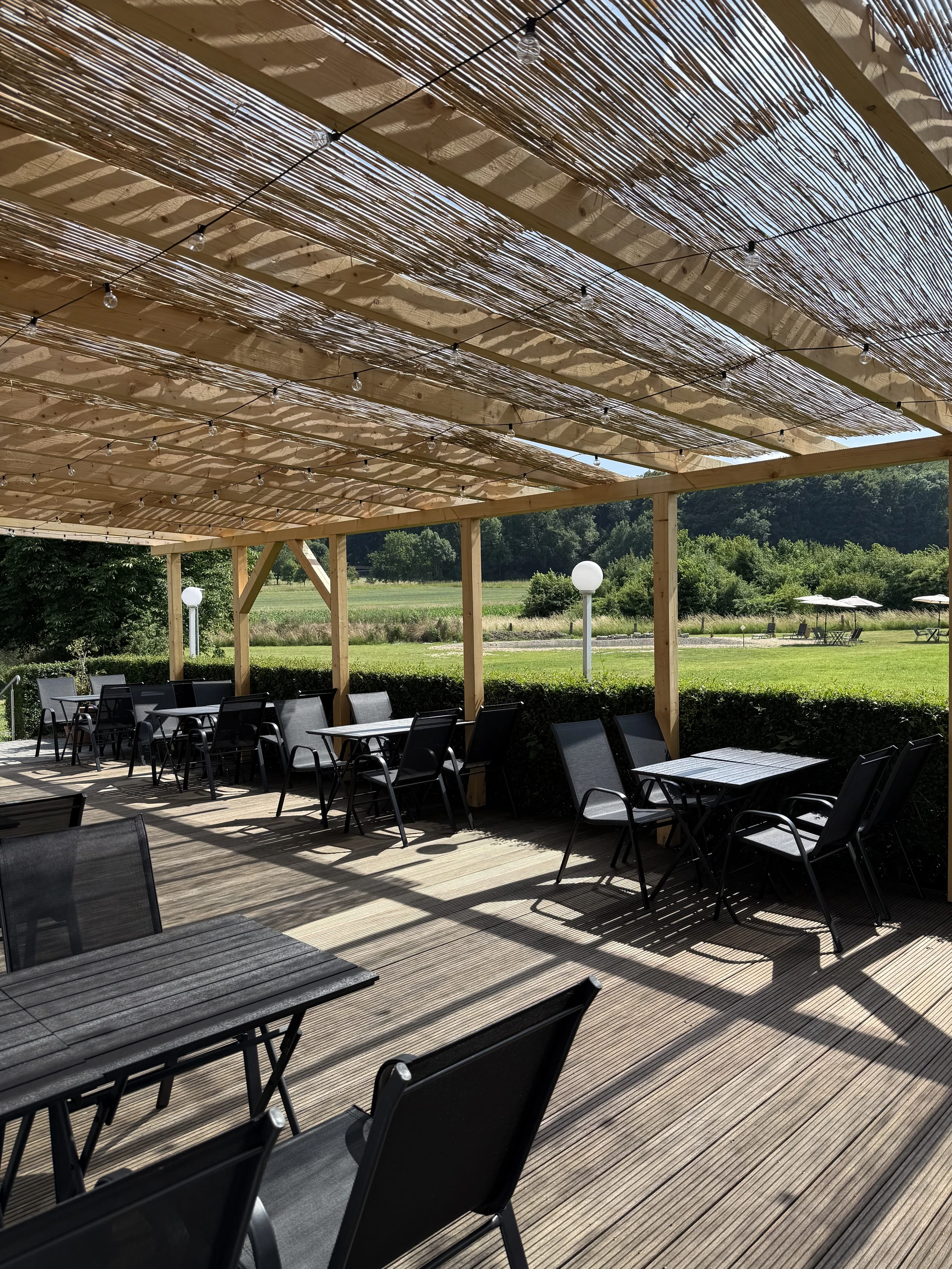 Überdachte Terrasse des PRADO mit Blick ins Grüne
